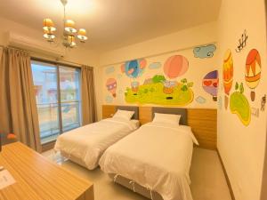 a bedroom with two beds and a wall with planets at 台東民宿秝之屋1945號 in Taitung City