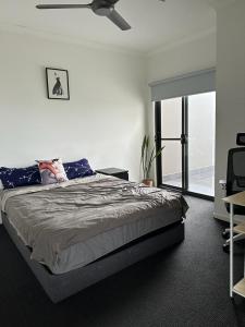 1 dormitorio con 1 cama y ventilador de techo en Best Brisbane location to enjoy vocation, en Brisbane