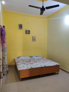 a bedroom with a bed in a yellow wall at Madhuban Homestay 1 Ujjain in Ujjain