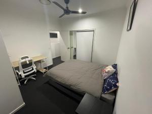 Habitación pequeña con cama, escritorio y silla. en Best Brisbane location to enjoy vocation, en Brisbane
