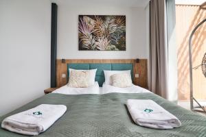 a bedroom with a bed with two towels on it at Apartamenty Laguna Beskidów - B39 in Zarzecze