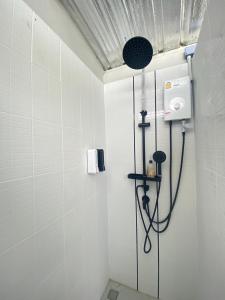 a shower in a bathroom with white tiles at Moon Camp Khaoyai in Ban Nong Song Hong