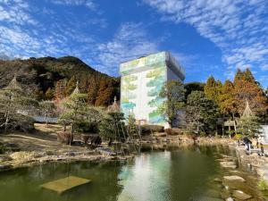 un edificio junto a un estanque en un parque en YudaOnsen Byakkoan　山口湯田温泉 白狐庵, en Yamaguchi