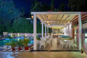 un patio con tavoli e sedie accanto alla piscina di Hotel Hindusthan International, Bhubaneswar a Bhubaneshwar