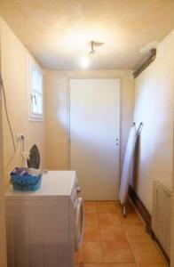 eine Waschküche mit einer weißen Tür und einem Kühlschrank in der Unterkunft La Rabouillère - House in Omaha Beach in Commes