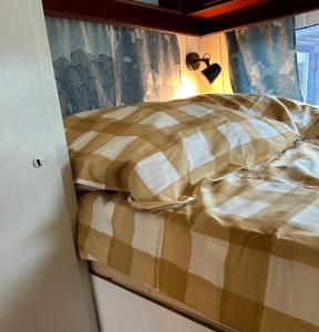a bed with a checkered blanket in a room at Campingplatz Mariengrund in Bernau am Chiemsee