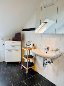 ein Bad mit einem Waschbecken und einem Spiegel in der Unterkunft FeWo Schmeer - Köllerbach in Püttlingen