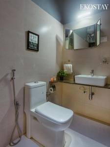 a bathroom with a white toilet and a sink at EKOSTAY - Neptune Villa in Igatpuri