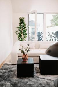 ein Wohnzimmer mit einem weißen Sofa und einem Tisch in der Unterkunft Modern Luxury Apartment Vienna in Wien