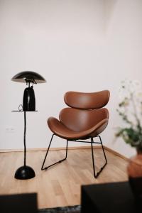 einen braunen Stuhl in einem Zimmer mit einer Lampe in der Unterkunft Modern Luxury Apartment Vienna in Wien