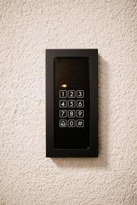 a black remote control on a white wall at Modern Luxury Apartment Vienna in Vienna