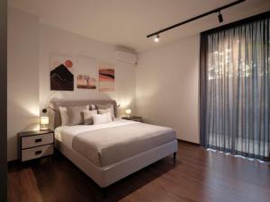 a bedroom with a white bed and a large window at Serene retreat in Glyfada in Athens