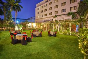 a garden venue with tables and lights and a building at Hotel Hindusthan International, Bhubaneswar in Bhubaneshwar