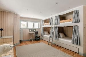 een slaapkamer met 2 stapelbedden en een bureau bij Seaside Bliss for Families: Home Away from Home in Stavsnäs