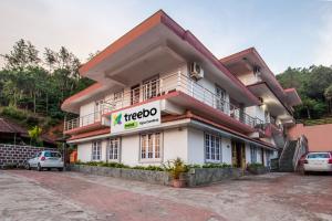 a building with a hellovisor sign in front of it at Treebo Trend Yajna Comforts in Madikeri