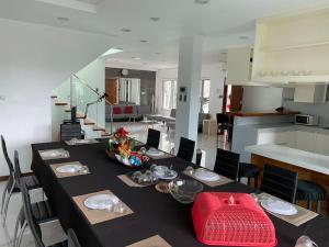ein Esszimmer mit einem langen Tisch und einer Küche in der Unterkunft 5 bedroom House antipolo in Antipolo