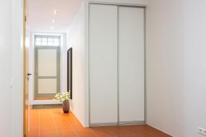 een glazen schuifdeur in een hal met een vaas met bloemen bij Gildi Apartment in Tartu