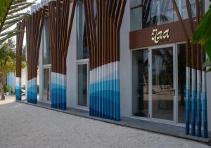 a facade of a building with blue and white windows at Stone Beach Club in Dhiffushi