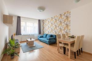 ein Wohnzimmer mit einem Tisch und einem blauen Sofa in der Unterkunft Prince downtown apartments with free parking in Budapest
