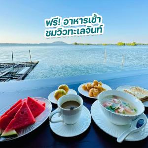 a table with plates of food and a cup of coffee at Meena Resort in Chanthaburi