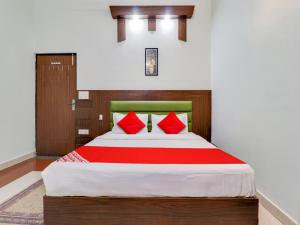 a bedroom with a large bed with red pillows at Hotel D.Homage in Dehradun