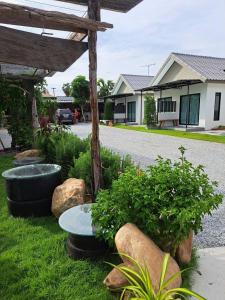 un giardino con rocce e un tavolo nell'erba di House number one a Ban Hua Khao Sammuk