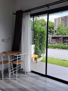 Habitación con mesa, sillas y ventana en House number one en Ban Hua Khao Sammuk