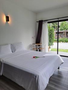 a bedroom with a white bed with a red rose on it at House number one in Ban Hua Khao Sammuk
