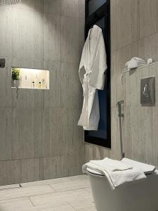 شقة فاخرة جديدة في الملقا Luxury في الرياض: حمام مع مرحاض ومنشفة معلقة على الحائط