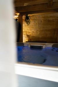 vistas a una bañera de hidromasaje con agua azul en Le temps suspendu, Suite troglodyte & SPA privé, en Doué-la-Fontaine