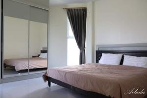 1 dormitorio con cama y espejo grande en Wonderland pool villa en Pattaya centro