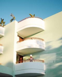 a woman sitting on a balcony of a building at Cubanito Ibiza in San Antonio