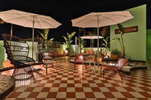 a room with chairs and umbrellas on a checkered floor at Cubanito Ibiza in San Antonio