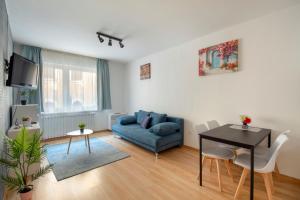 ein Wohnzimmer mit einem blauen Sofa und einem Tisch in der Unterkunft Prince downtown apartments with free parking in Budapest