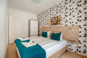 Schlafzimmer mit einem Bett mit grünen und weißen Kissen in der Unterkunft Prince downtown apartments with free parking in Budapest