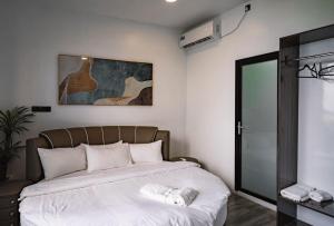 una camera da letto con un grande letto con lenzuola bianche di Bibee Maldives a Dhiffushi