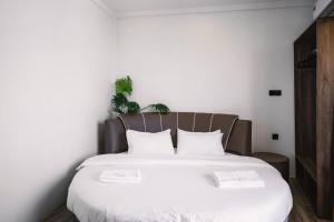 1 dormitorio con 1 cama blanca grande y 2 almohadas en Bibee Maldives, en Dhiffushi