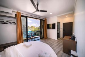 Habitación de hotel con cama y balcón en Bibee Maldives, en Dhiffushi
