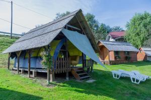 una pequeña casa con un techo inclinado en un patio en Camping Silva en Ljutomer