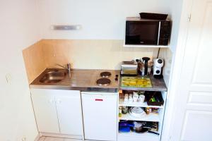 a small kitchen with a sink and a microwave at Proche rempart avec Parking sécurisé in Avignon
