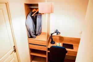 a room with a desk with a jacket and a lamp at Proche rempart avec Parking sécurisé in Avignon