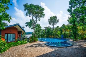 a swimming pool in front of a house at Vyna Hillock Resort and Spa in Vythiri