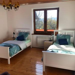 a bedroom with two beds and a window at Agroturystyka Zagroda Miłkowskie in Słopnice