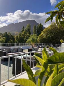 a balcony with a couch and a view of a mountain at Hotel du Vin Franschhoek in Franschhoek