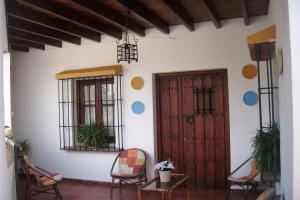 um quarto com duas cadeiras e uma porta de madeira em Casa Villazo II em Almáchar