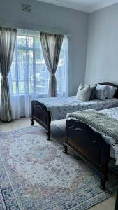 a bedroom with two beds and a large window at Lilibeth guesthouse in Parys