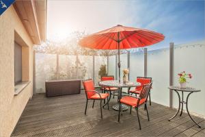 eine Terrasse mit einem Tisch, Stühlen und einem Sonnenschirm in der Unterkunft Ferienhaus Janina Ferienhaus Janina in Zinnowitz