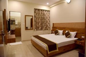 a bedroom with a large bed and a bathroom at Hotel Golden Tower At Delhi Airport in New Delhi