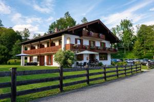 ein Haus mit einem Zaun davor in der Unterkunft Hotel Garni Landhaus Sonnenstern in Schönau am Königssee