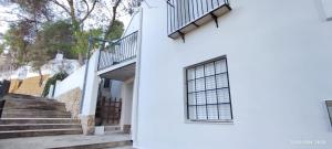 a white building with a window and stairs at Alojamiento Turístico Casa Elvira in Yecla